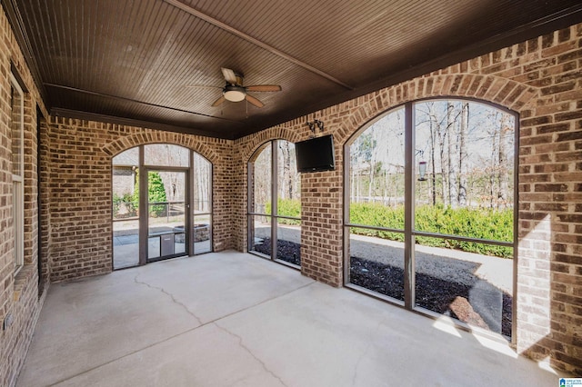 unfurnished sunroom with ceiling fan