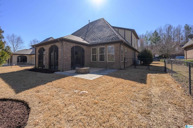 view of front of property with an outdoor fire pit, a patio, fence, a front lawn, and brick siding