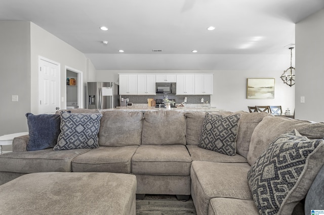 living area with vaulted ceiling, a chandelier, visible vents, and recessed lighting