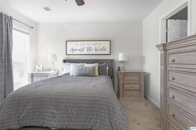 carpeted bedroom featuring baseboards, visible vents, and a ceiling fan