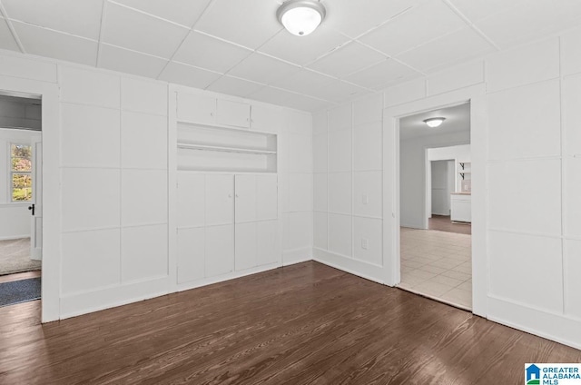 unfurnished room featuring dark wood-style floors and a drop ceiling