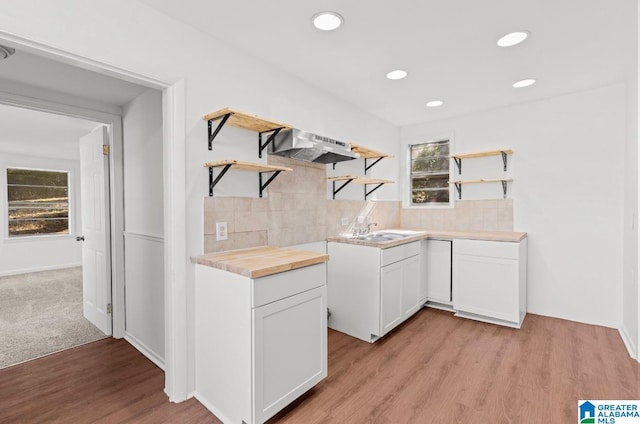 kitchen with range hood, a healthy amount of sunlight, decorative backsplash, and open shelves