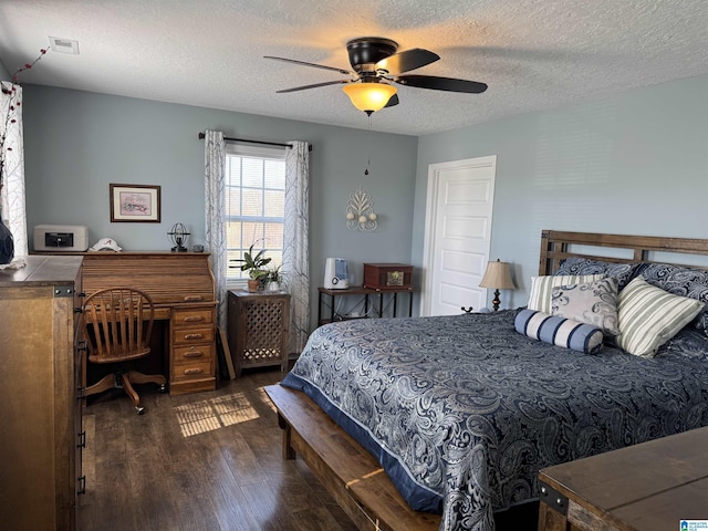 bedroom featuring a textured ceiling, wood finished floors, visible vents, and a ceiling fan