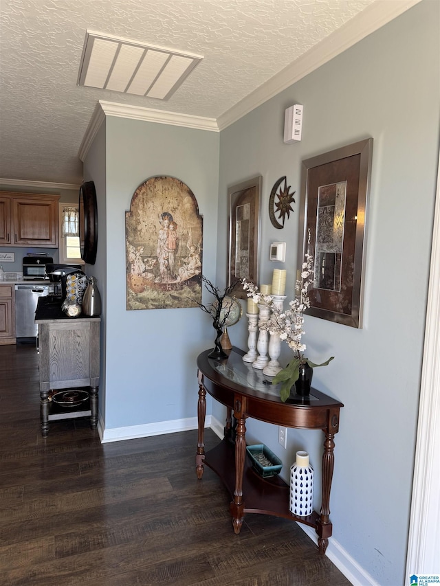 hallway with a textured ceiling, dark wood finished floors, and crown molding