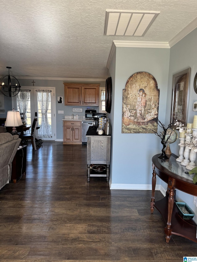 interior space with dark wood-style flooring, crown molding, an inviting chandelier, a textured ceiling, and baseboards