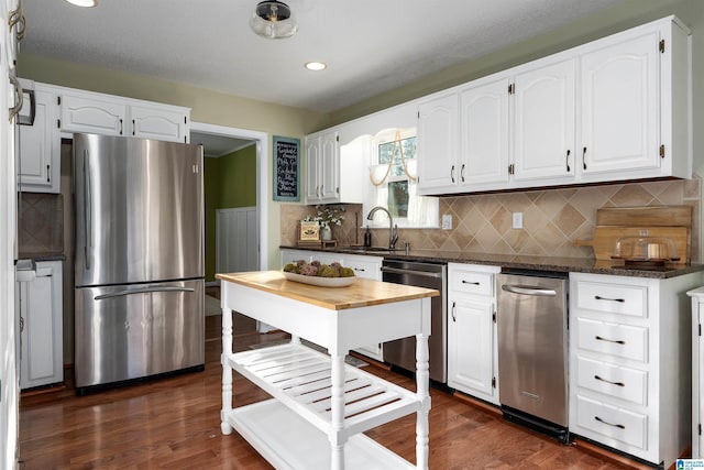 kitchen featuring a sink, appliances with stainless steel finishes, white cabinets, and dark wood finished floors