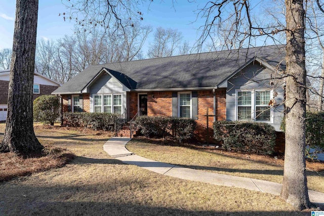 ranch-style home featuring a shingled roof and brick siding