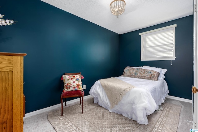 bedroom featuring carpet floors, baseboards, and a textured ceiling