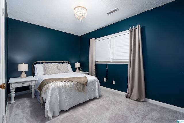 carpeted bedroom with baseboards, visible vents, and a textured ceiling