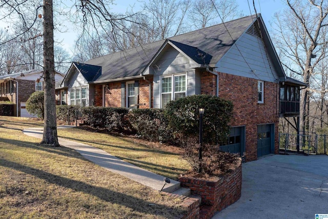 view of front of home featuring a front lawn, brick siding, driveway, and an attached garage