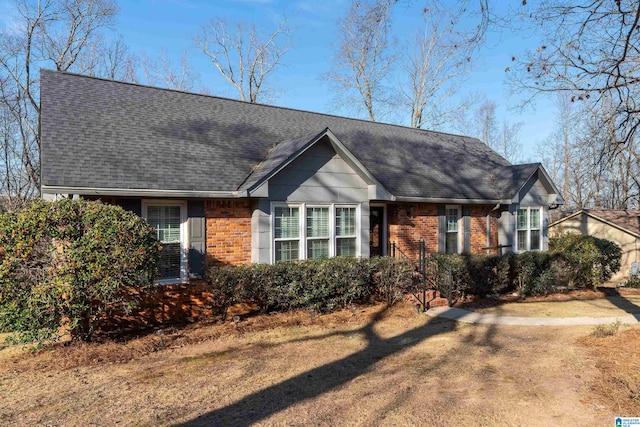 view of front of house with a shingled roof and brick siding