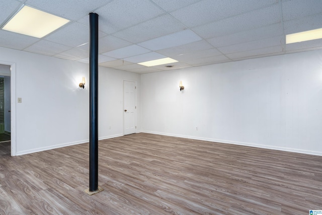 finished basement with a drop ceiling, baseboards, and wood finished floors