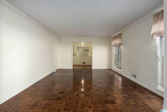 spare room with visible vents, crown molding, and baseboards