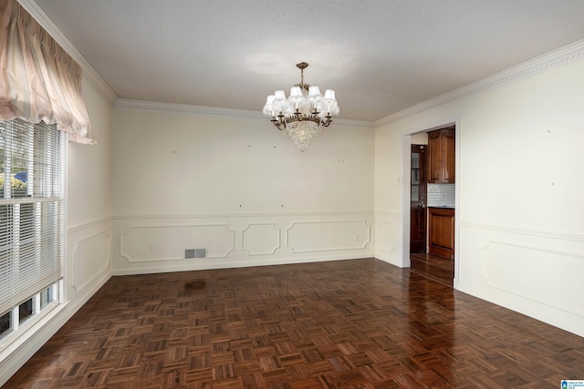 spare room featuring visible vents, an inviting chandelier, ornamental molding, and wainscoting