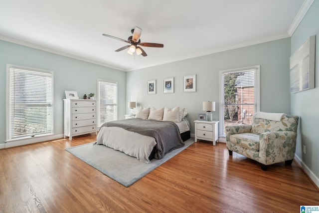 bedroom with ornamental molding, ceiling fan, baseboards, and wood finished floors