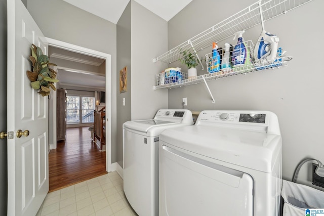 laundry area with laundry area, light tile patterned floors, baseboards, and washer and clothes dryer