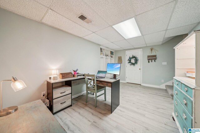 office with a paneled ceiling, visible vents, baseboards, and wood finished floors