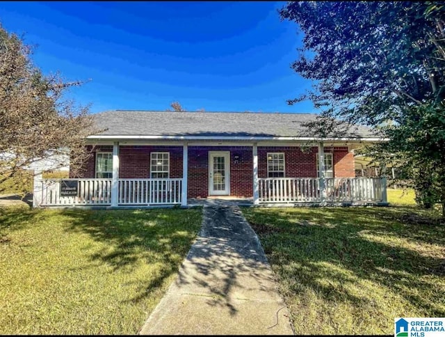 ranch-style home with a porch, a front yard, and brick siding