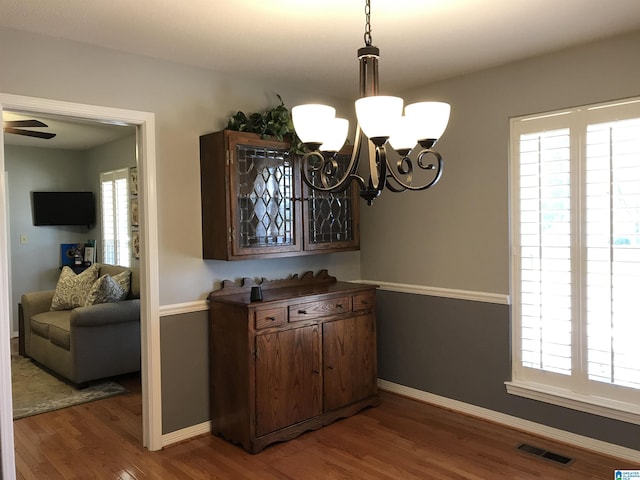 dining space with a wealth of natural light, visible vents, baseboards, and wood finished floors