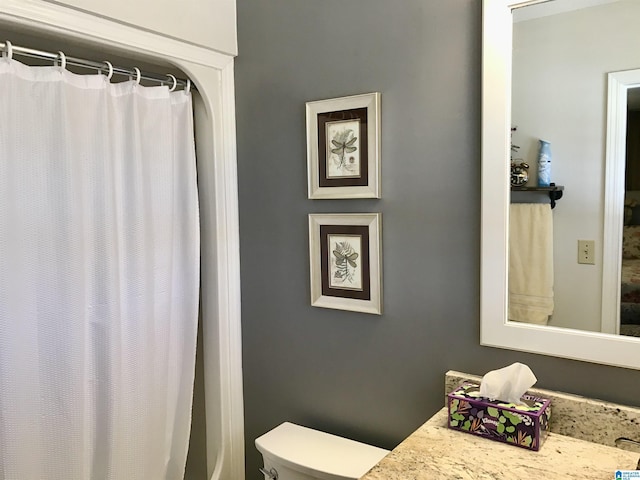 bathroom featuring vanity, a shower with shower curtain, and toilet