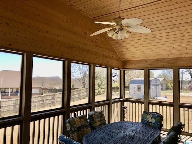 sunroom featuring lofted ceiling, a ceiling fan, a residential view, and wooden ceiling