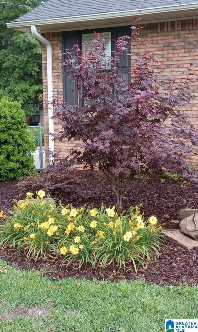 exterior space with brick siding and a shingled roof