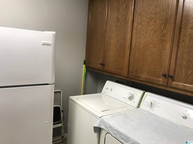 washroom with cabinet space and washer and clothes dryer