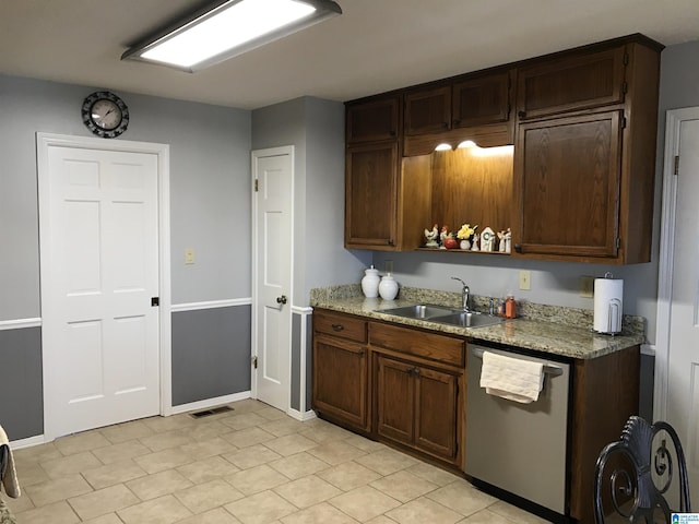 kitchen with stainless steel dishwasher, light stone countertops, visible vents, and a sink