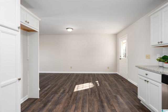 unfurnished dining area with dark wood-style floors and baseboards