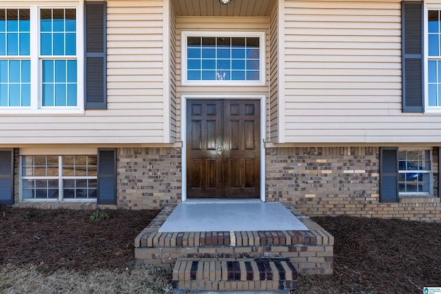 entrance to property featuring brick siding