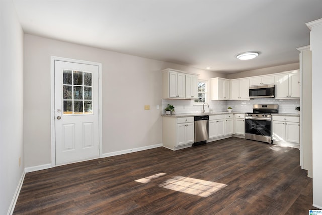 kitchen with stainless steel appliances, backsplash, baseboards, and dark wood-style floors