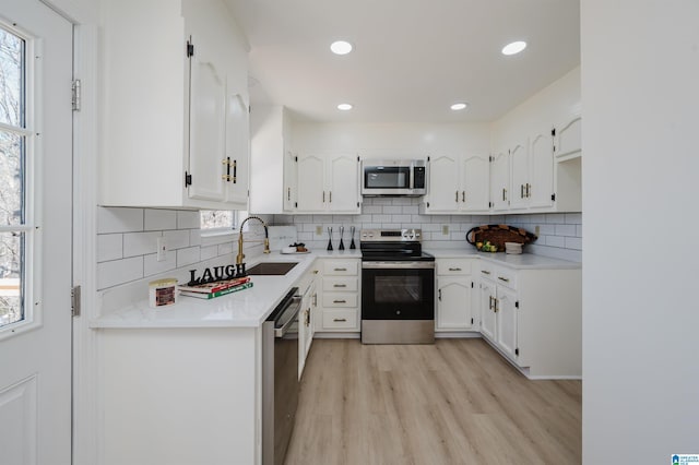 kitchen featuring stainless steel appliances, plenty of natural light, white cabinets, and a sink