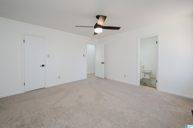 unfurnished bedroom with light carpet, baseboards, a ceiling fan, and ensuite bathroom