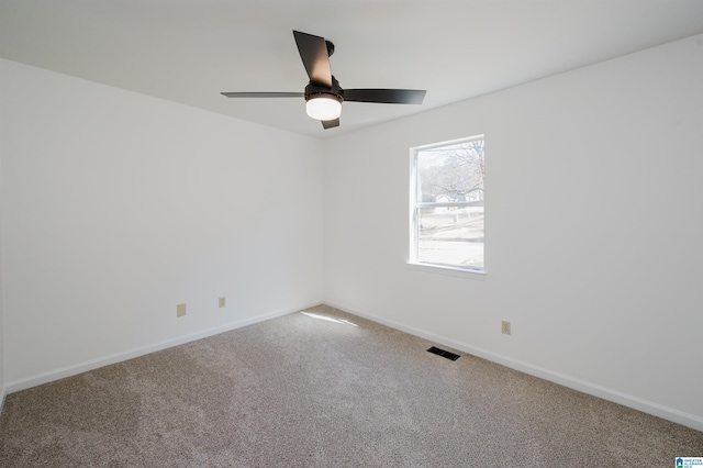 carpeted empty room with a ceiling fan, visible vents, and baseboards