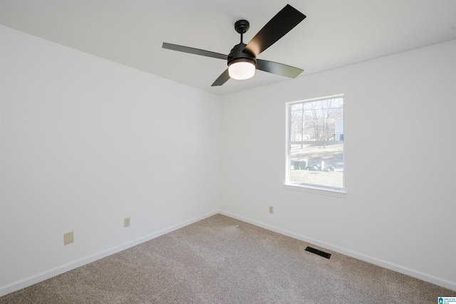 carpeted empty room featuring a ceiling fan, visible vents, and baseboards