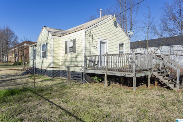 rear view of house featuring a deck, metal roof, fence, stairs, and a yard