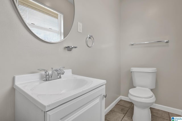 bathroom featuring toilet, vanity, baseboards, and tile patterned floors