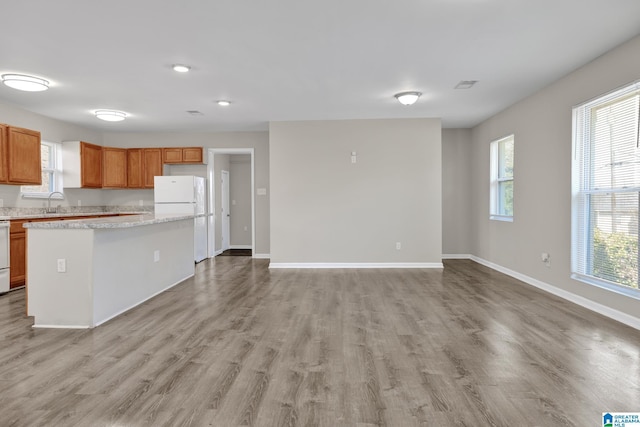 kitchen featuring light countertops, visible vents, light wood-style floors, freestanding refrigerator, and baseboards