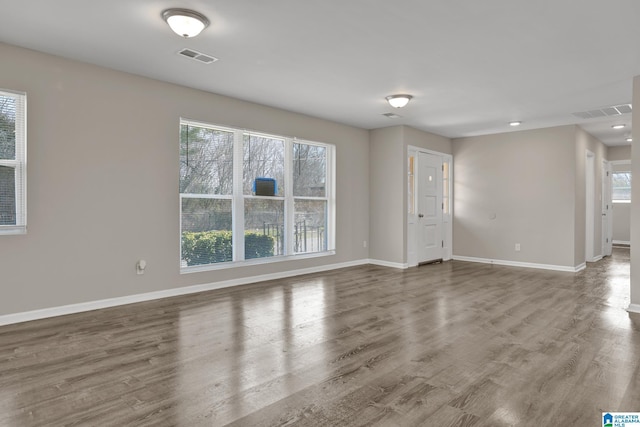 unfurnished room with visible vents, baseboards, and wood finished floors