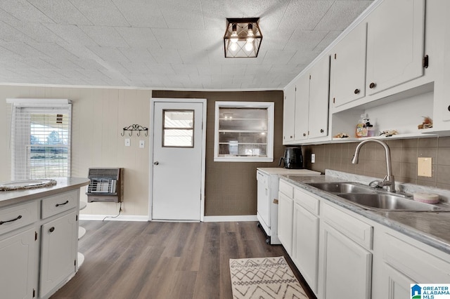 kitchen featuring heating unit, white cabinets, dark wood-type flooring, and a sink