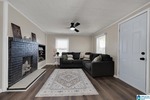 living area featuring baseboards, dark wood-style flooring, a fireplace, and crown molding