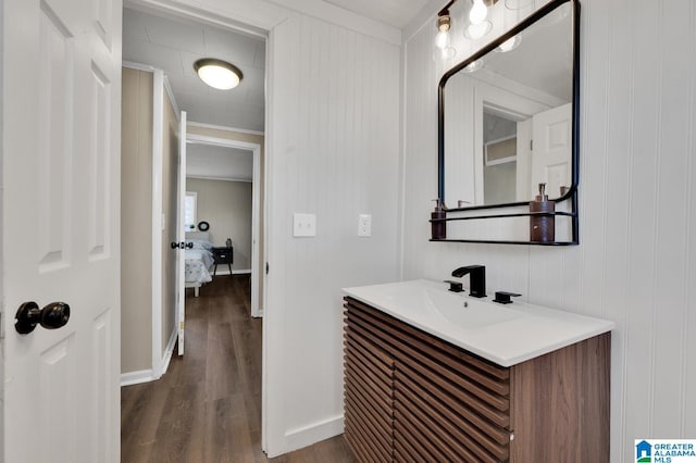 bathroom featuring vanity, baseboards, and wood finished floors