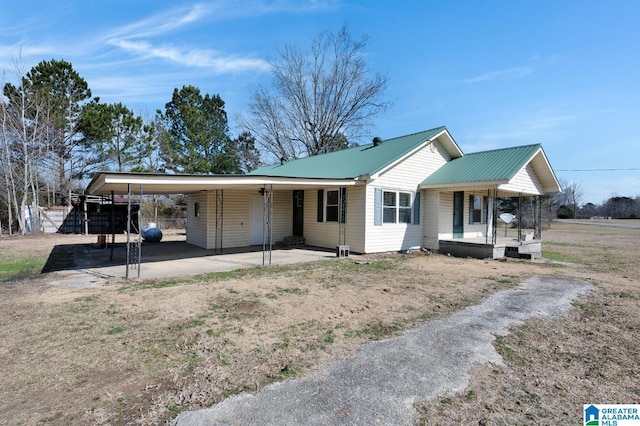 view of front of home with an attached carport, covered porch, and metal roof