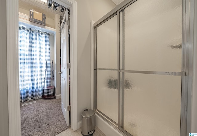 full bath with a shower with shower door and visible vents