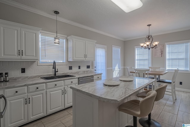 kitchen featuring decorative backsplash, white cabinetry, a kitchen island, a sink, and dishwasher