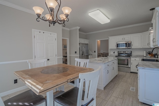 kitchen featuring backsplash, appliances with stainless steel finishes, white cabinets, a sink, and a kitchen island