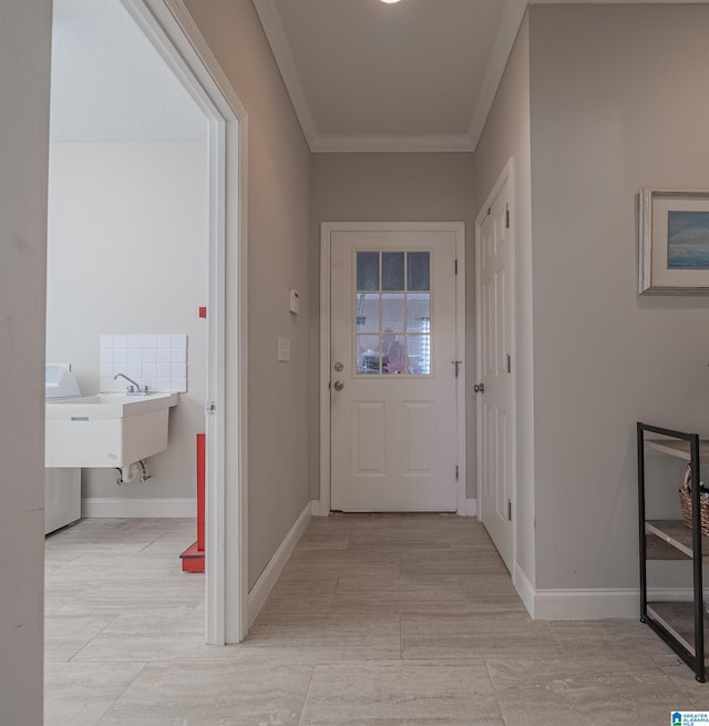 entryway featuring baseboards and crown molding