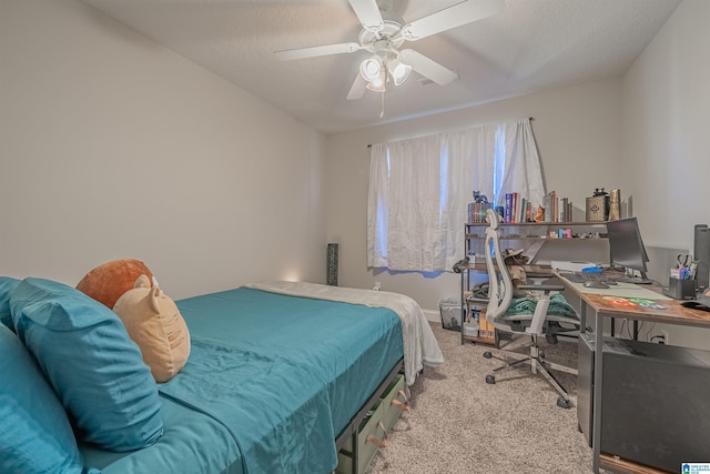 carpeted bedroom featuring ceiling fan and a textured ceiling