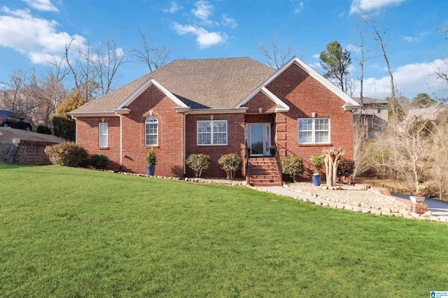 single story home featuring brick siding, a shingled roof, and a front yard