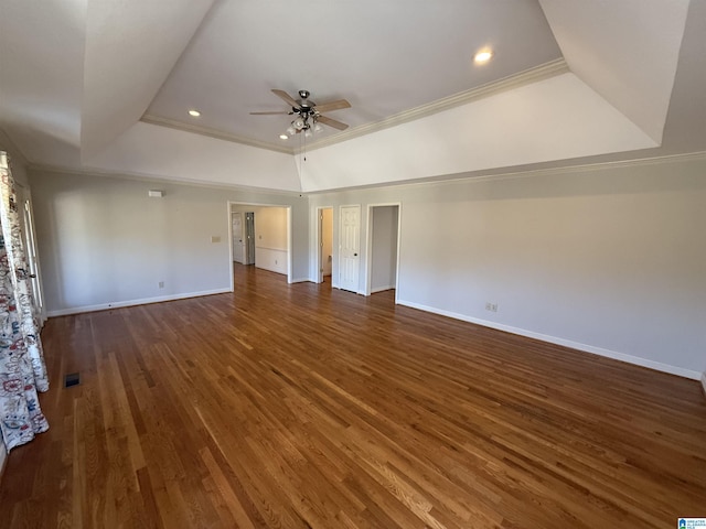 unfurnished living room with crown molding, a raised ceiling, a ceiling fan, wood finished floors, and baseboards